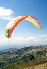 Two people taking off, paragliding post covid-19 with mask