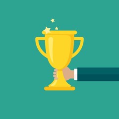 Hand with gold trophy, winning cup isolated on blue background.