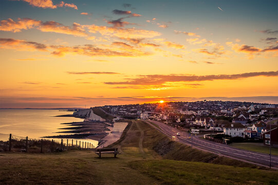 The view from Saltdean as the sun slips below the horizon at Brighton, UK in summer