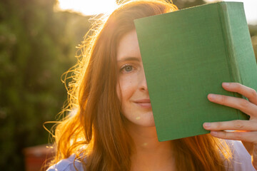 Portrait of redheaded woman with green book