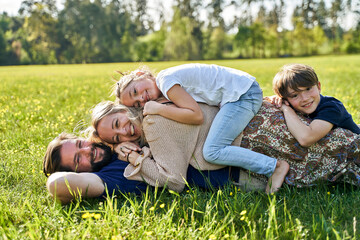 Smiling family lying on grass during sunny day