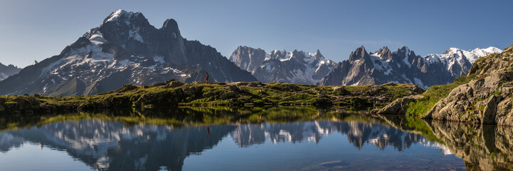 hiker in mountains with reflection in lake