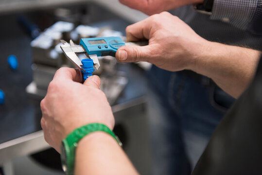Close-up of man examining product with a caliper