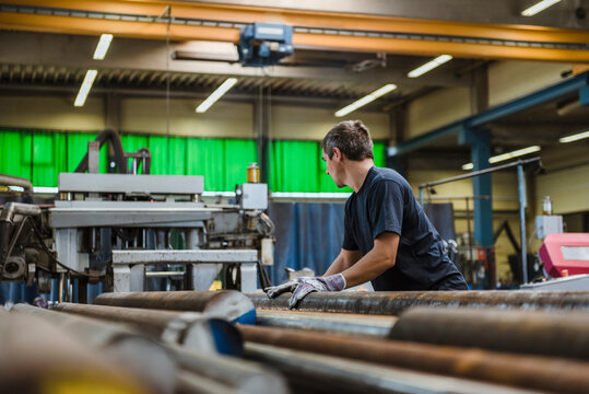 Man working with metal bars in a factory