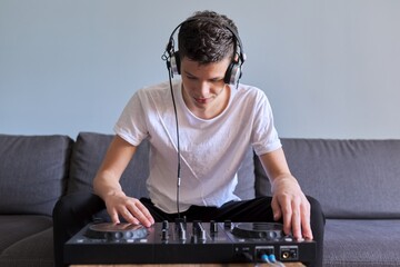 Creative teen boy in headphones with mixer equipment entertainment dj station