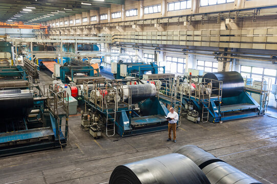 Senior businessman with folder in a rubber processing factory