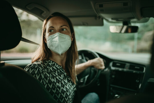 Mid adult woman with protective mask in car