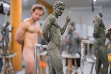 Sculpture and naked model in the background