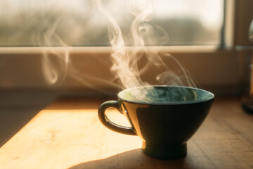 Steam rising from freshly prepared coffee in cup on table at home