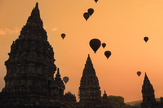 Indonesia, Java Island, Silhouettes of hot air balloons flying over Prambanan temple at moody dusk