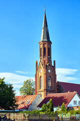 Fototapeta na wymiar The tower of the historic gothic red brick church in the city of Lubniewice