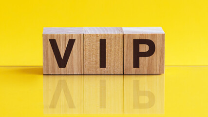 Word VIP made with wood building blocks on a light yellow background