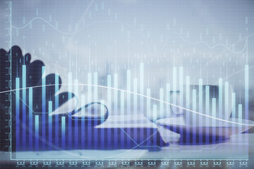 Double exposure of financial chart drawing and desktop with coffee and items on table background....