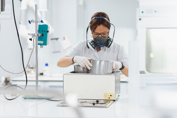 Confident female technician doing research while using medical equipment at laboratory
