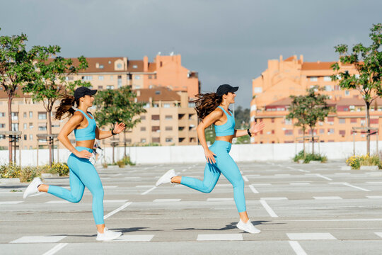 Young twins running at parking lot