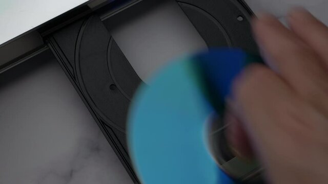 Man Of Hand Remove Disc From The Device DVD/CD Player. Top View DVD Disc, Eject Tray And Extract Disc In DVD-player. .