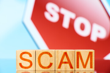 scam. wooden blocks with scam inscription and stop sign on background