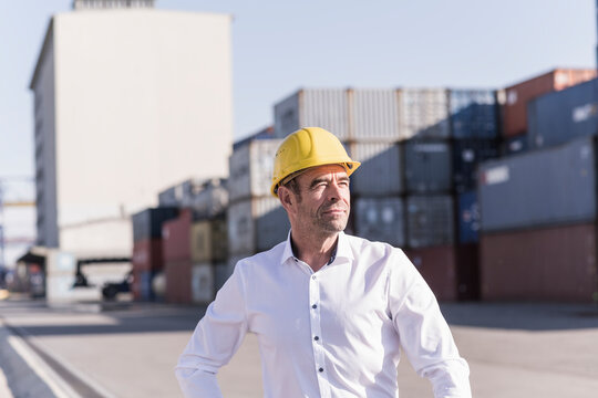 Portrait of businessman wearing safety helmet at industrial site