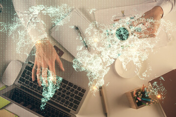 Double exposure of man's hands typing over computer keyboard and social network theme hologram drawing. Top view. People connection web concept.