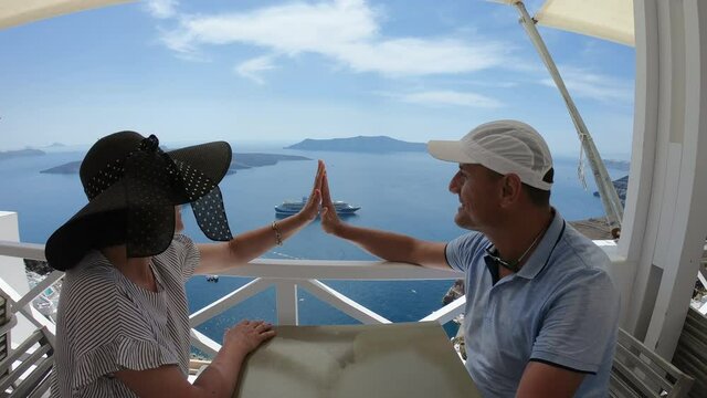 Couple on vacation at the Greek village Oia Santorini Greece sitting in taverna with panoramic view