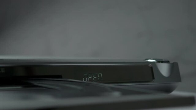 DVD Player Display. Eject Tray And Insert Disc In DVD-player. Male Hand Loading Disc Into The Device DVD/CD Player.