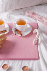 breakfast in bed with fruits and pastries on a tray -waffles, croissants, coffe and juice