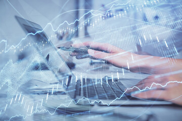 Multi exposure of woman hands typing on computer and financial graph hologram drawing. Stock market analysis concept.