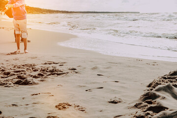 Little boy is playing on the beach by the sea. Vacation and lifestyle concept. A child on vacation spends time at the seaside, playing in the sand.