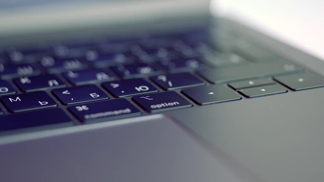 Close up of elegant modern laptop details. Action. Concept of modern technologies, Black keaboard and touch pad of a computer lying on white blurred background.