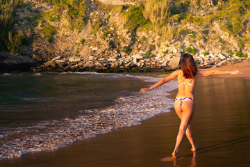 Young caucassian girl with a colorful bikini possing at Zarautz beach.