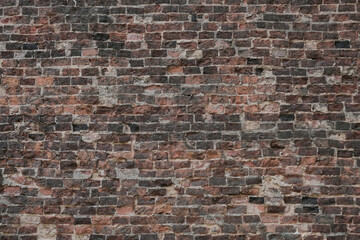 Old red brick damaged wall background and exposed brickwork texture.