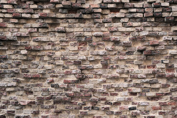 Old red brick damaged wall background and exposed brickwork texture.