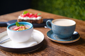Strawberry dessert and coffee on a table in a summer cafe, close up