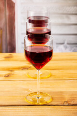Three glasses of red wine on a wooden background. Shallow depth of field. Blurred background