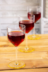 Three glasses of red wine on a wooden background. Shallow depth of field. Blurred background