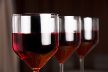 Three glasses of red wine on a dark background. Shallow depth of field. Blurred background