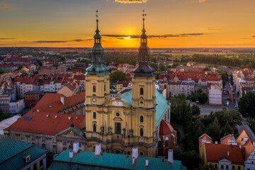 Beautifully setting sun between the twin towers of the Parish of St. John the Baptist. A day ending in the old part of the city and its historic buildings in Legnica, Poland