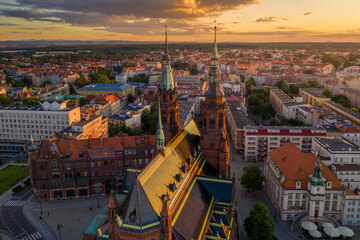 Aerial drone view of old town buildings and the Cathedral of St. Peter and Paul the Apostles and  before sunset. The sun's rays beautifully highlight the urban old architecture in Legnica, Poland