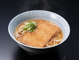 Udon noodles in a hot soup with deep fried tofu