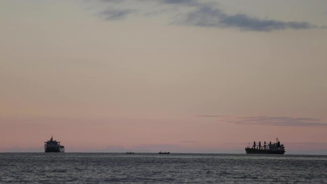 Fishing boats and freighters at sunset in Central America