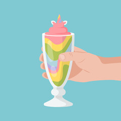 Hand holds a Rainbow milkshake with unicorn.