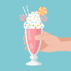 Hand holds a Strawberry milkshake