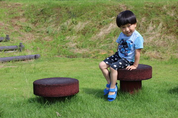 アスレチックの遊具に座る園児