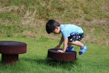 アスレチックの遊具によじ登る男児