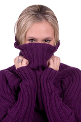 Beautiful blond model pulling purple sweater up for facial covering