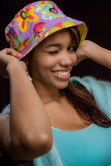 Pretty woman with a colorful hat winking