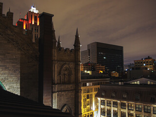 view of the city from the top of a church at night with the street below