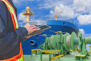 Engineer holding digital tablet control shipping containers cargo, Container freighter docks. Mooring wind, Mooring windlass and front ship background.