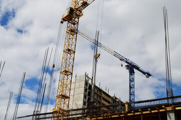 two construction cranes are building a high-rise building