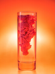 Acrylic ink in water. Abstract red paint in glass of water. Monochrome color theme